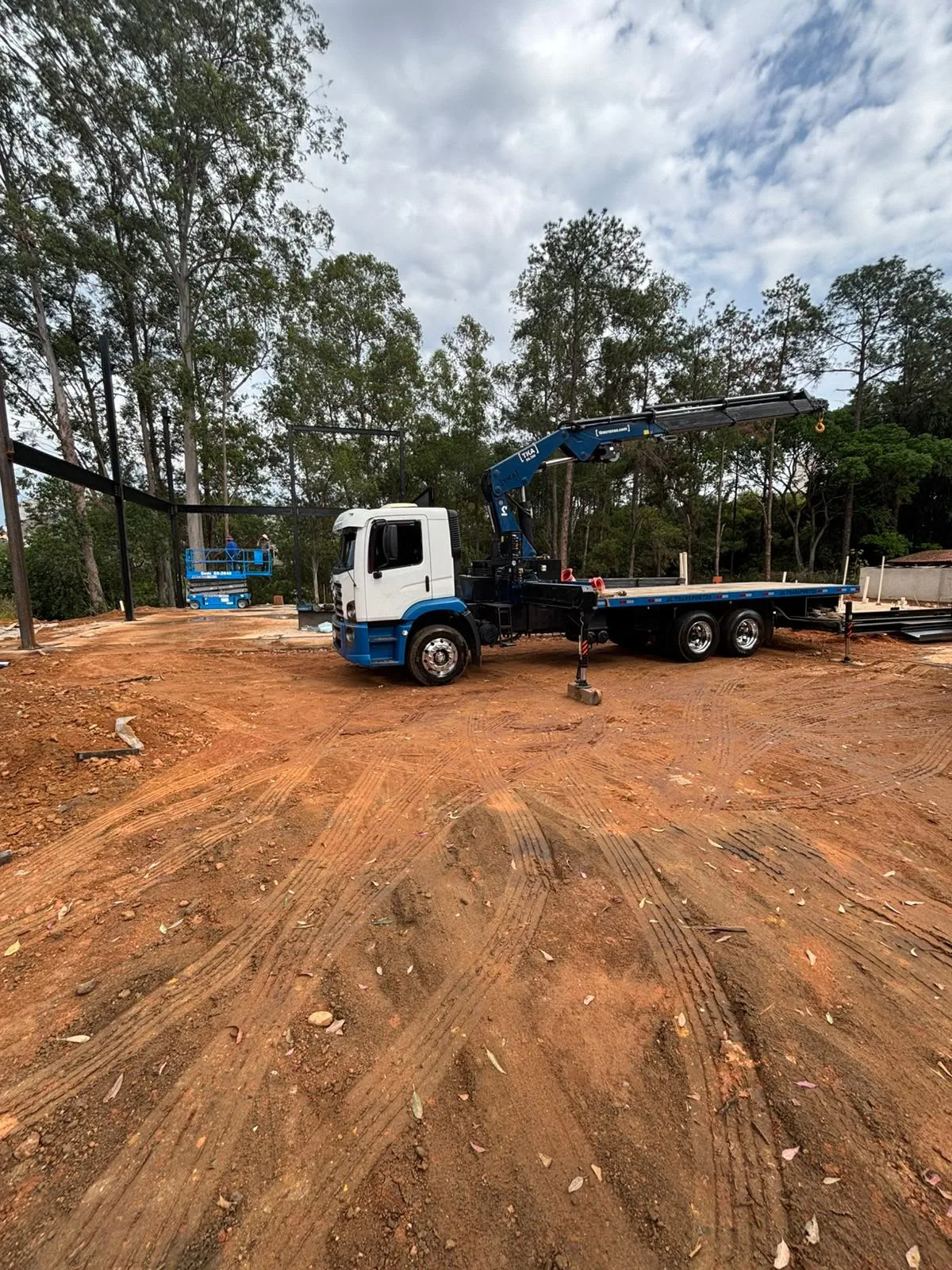 Caminhão Munck em operação com operador em canteiro de obras