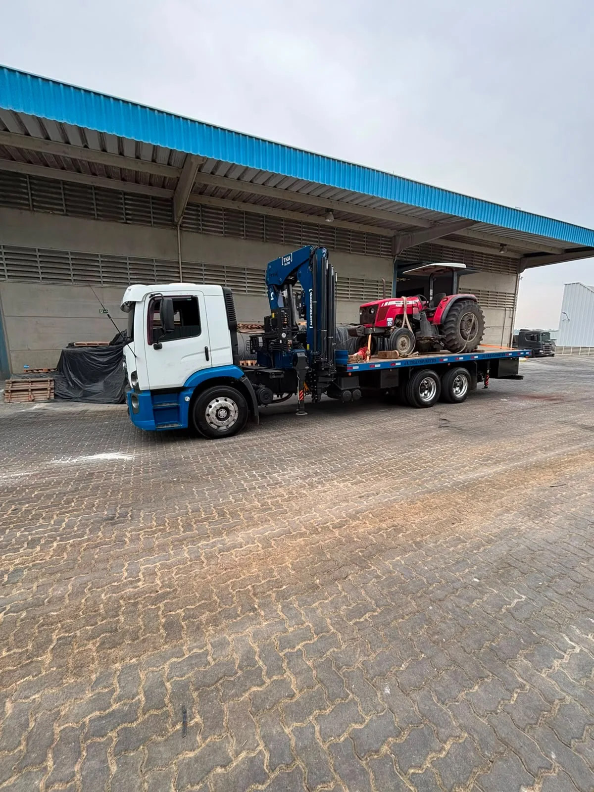 Transporte de máquina industrial pesada amarrada sobre caminhão Munck